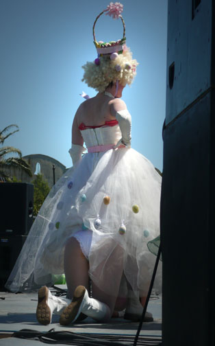 Woman in white dress with another woman under her dress