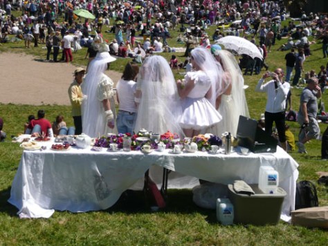 Bay-Area-Backsides-Sarah-Curtiss-Easter-Dolore-Park-Mission-District-Wedding-Dress-White 4 men dressed in bridal gowns in front of a wedding table