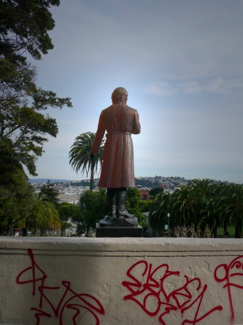 Dolores Park statue from the back with graffiti in the foreground