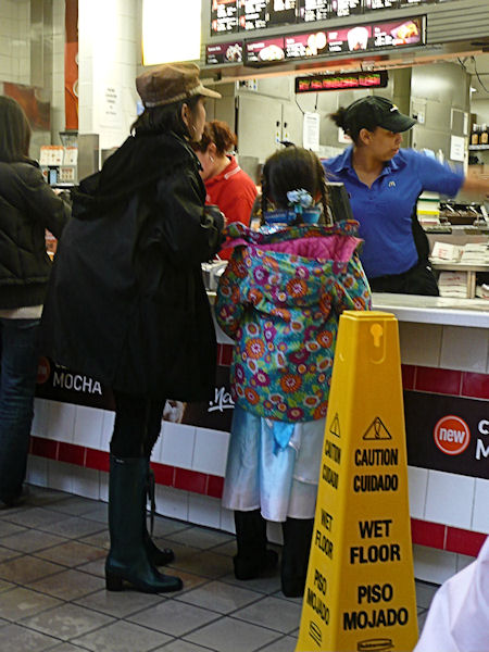 woman and child in line at McDonalds on a rainy day