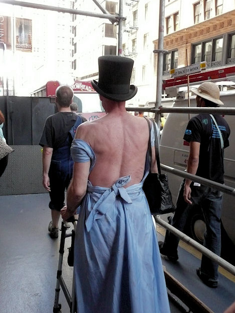 man with walker in backless evening gown and top hat
