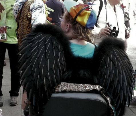 fine art photograph by san francisco artist sarah curtiss of woman in wheel chair with black wings at st stupids day parade