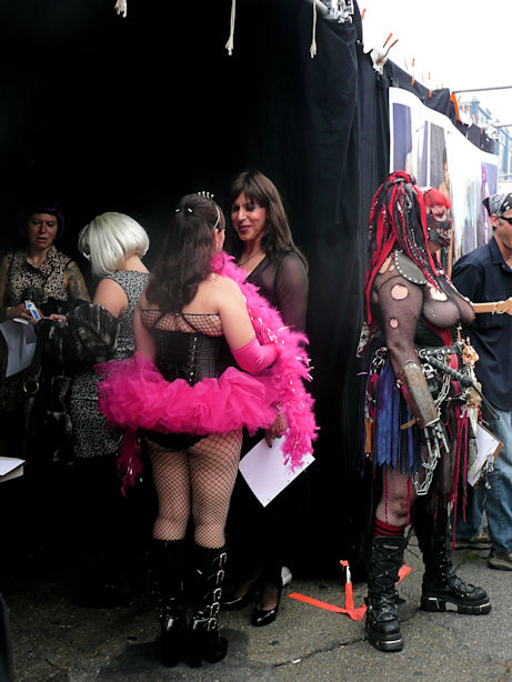 woman in black corset with hot pink tutu and fishnet stockings, high black boots