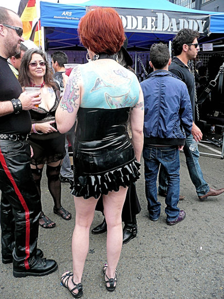 tattooed woman in black rubber dress