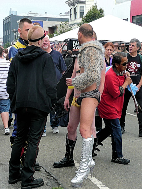 man in short fur coat and stiletto heeled silver boots