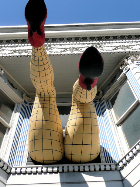fake legs and butt in fishnet stockings coming out of window on haight street